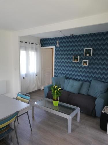 ein Wohnzimmer mit einem Sofa und einem Tisch in der Unterkunft La Houle, maison classée 4 étoiles in Criel-sur-Mer