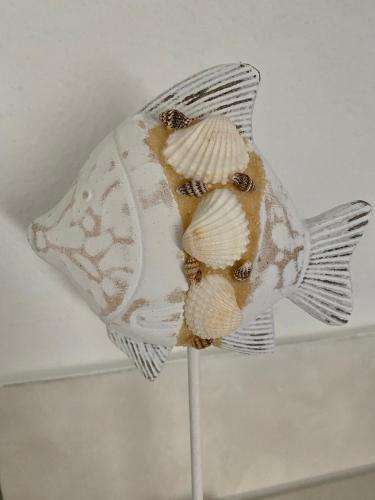 a fish on a stand with a shell on it at Steigerwaldblick Apartments Burgebrach in Burgebrach