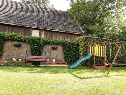 a playground with a swing and a bench in a yard at Privat Mária in Liptovský Ján