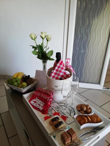 a table with a plate of food and a bowl of fruit at AU NID COSY D'ISA A GERARDMER VOSGES - Spas privatifs in Gérardmer