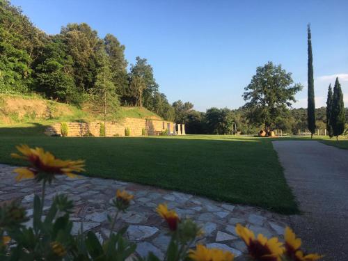 a park with a path and flowers in the foreground at Can Homs in Beuda