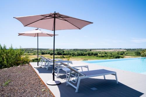 a group of chairs and umbrellas next to a pool at I Carusi Relais in Noto