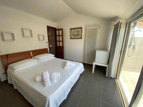 Un dormitorio con una cama blanca con toallas. en Economy Rooms, en Vernazza