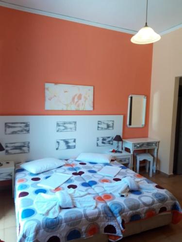 ein Bett in einem Schlafzimmer mit einer orangefarbenen Wand in der Unterkunft Nidri Studios Apartments in Nydri