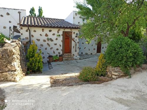 a small house with a door in a yard at CASA RURAL "LOS CASARES" in Nerpio