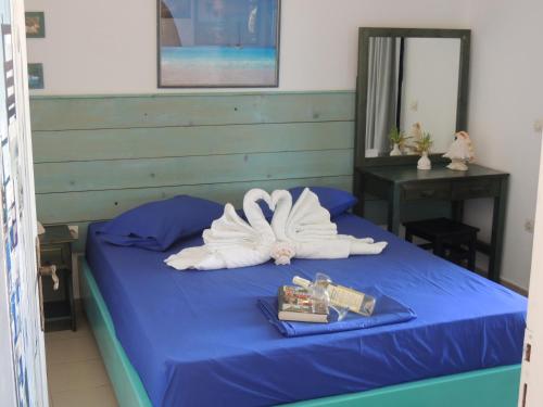 a bed with a pile of towels on it at Kalamitsi Studios in Kalamitsi