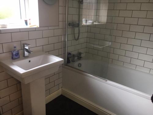 a bathroom with a sink and a tub and a shower at The Annexe - Acomb Green in York
