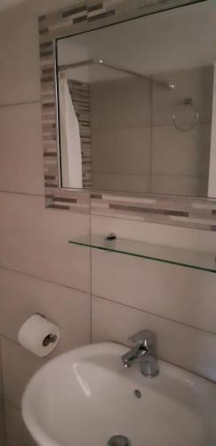 a bathroom with a white sink and a mirror at Antonia Rooms in Anafi