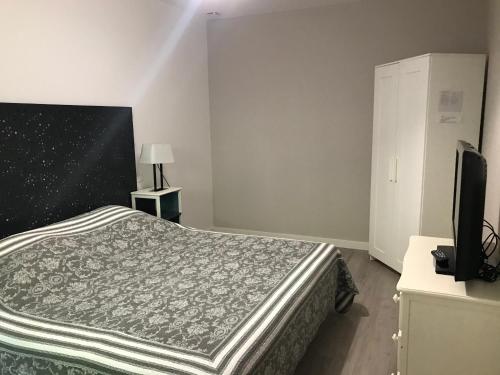 een slaapkamer met een bed en een flatscreen-tv bij Les Tourterelles in Saint-Aygulf