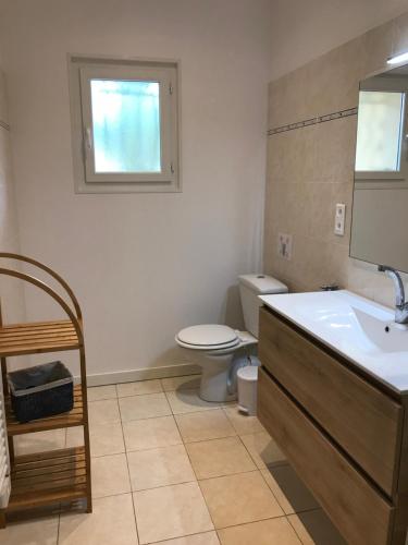 a bathroom with a sink and a toilet and a window at Les Tourterelles in Saint-Aygulf