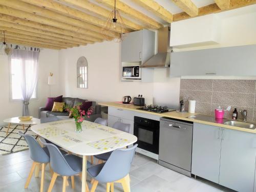 a kitchen and living room with a table and chairs at Casa Louka in Saint-Aignan