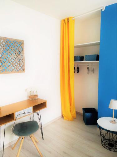 Cette chambre dispose d'un bureau et de rideaux jaunes. dans l'établissement Casa Louka, à Saint-Aignan