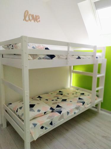 - une chambre avec des lits superposés et un panneau d'amour sur le mur dans l'établissement Casa Louka, à Saint-Aignan