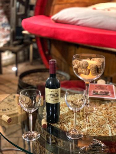 a bottle of wine and two wine glasses on a table at Al Silter in Capriate San Gervasio