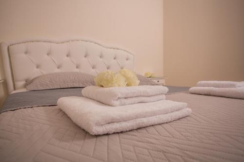 a bed with a bunch of towels on it at Pistakion Houses in Aegina Town