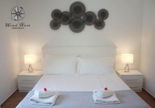 a bedroom with a large white bed with two lamps at Wind Rose Apartments 2 in Nago-Torbole
