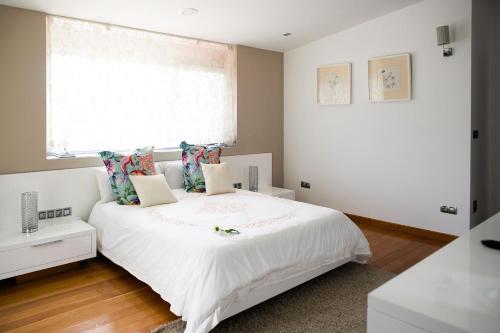 a bedroom with a white bed and a window at Chalet Vilanova in Cee