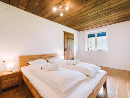 una camera da letto con un letto grande con lenzuola bianche di Apartment WILKY in Kaprun a Kaprun