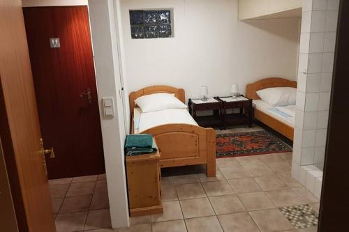 ein kleines Schlafzimmer mit 2 Betten und einem Tisch in der Unterkunft Ferienwohnung und Monteurwohnung mit großer begehbarer Dusche in Lünen
