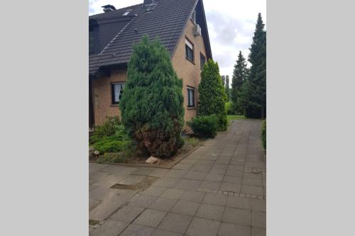 a house with a tree next to a street at Ferienwohnung und Monteurwohnung mit großer begehbarer Dusche in Lünen