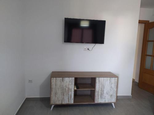 una TV a schermo piatto in cima a un muro bianco di COSTA DE ALMERIA PLAYA a Almería