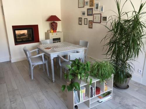 a dining room table with chairs and potted plants at les chambres de Marthe in Mesnay