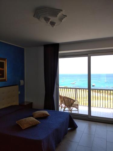 a bedroom with a bed and a view of the ocean at B&B Aquila Reale in Portopalo