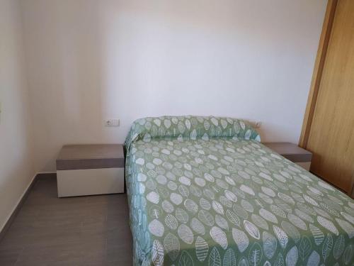ein kleines Schlafzimmer mit einem Bett mit grüner Decke in der Unterkunft COSTA DE ALMERIA PLAYA in Almería