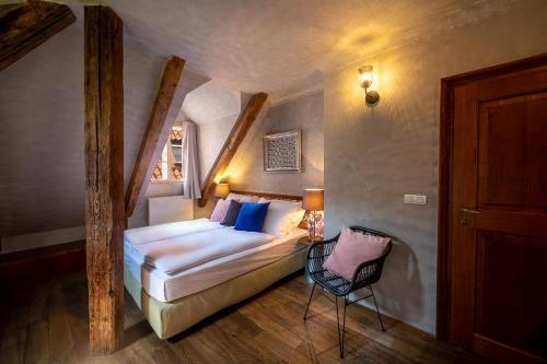 ein Schlafzimmer mit einem Bett und einem Stuhl in einem Zimmer in der Unterkunft Miss Sophie's Charles Bridge in Prag