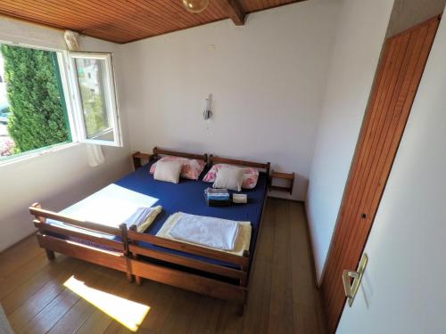 1 dormitorio con 1 cama en una habitación con ventana en Apartment Gašparević, en Rogoznica