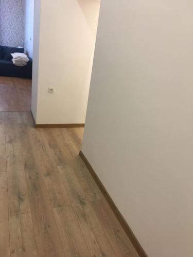 a room with a white wall and a wooden floor at Ekaterina Appartment 2 in Odesa