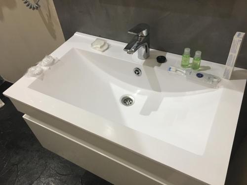 a white sink with a faucet in a bathroom at Ekaterina Appartment 2 in Odesa