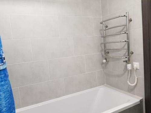 ein Badezimmer mit einer Dusche und einer weißen Badewanne in der Unterkunft Новая и уютная квартира в центре in Uschhorod