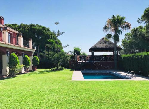 a backyard with a gazebo and a swimming pool at VILLA NABRISA MARBELLA, 5 BEDROOM, PRIVATE POOL, GARDEN, BBQ in Marbella