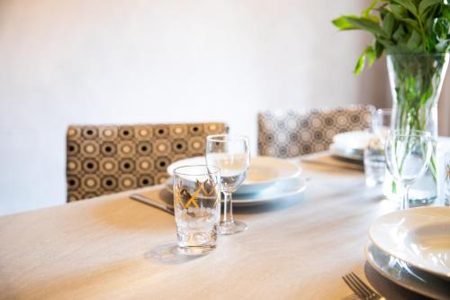 a wooden table with glasses and plates and a vase on it at Miss Sophie's Charles Bridge in Prague