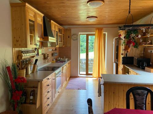 eine große Küche mit Holzschränken und einem großen Fenster in der Unterkunft Ubytovanie v súkromí - Chata Zejmarka in Mlynky 