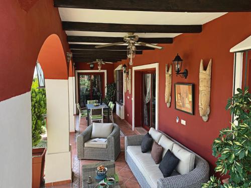 a porch with two chairs and a ceiling fan at VILLA NABRISA MARBELLA, 5 BEDROOM, PRIVATE POOL, GARDEN, BBQ in Marbella