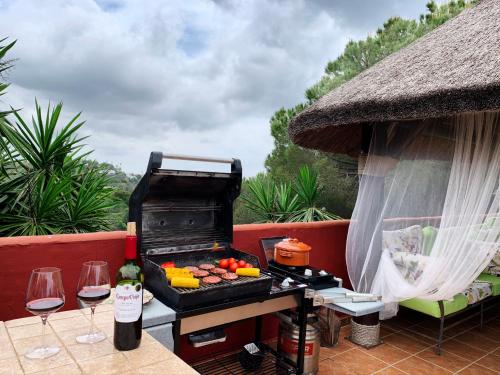a grill on a patio with two glasses of wine at VILLA NABRISA MARBELLA, 5 BEDROOM, PRIVATE POOL, GARDEN, BBQ in Marbella