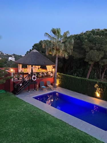 a backyard with a swimming pool and a gazebo at VILLA NABRISA MARBELLA, 5 BEDROOM, PRIVATE POOL, GARDEN, BBQ in Marbella