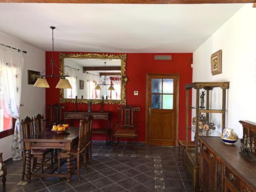 a dining room with red walls and a table and a mirror at VILLA NABRISA MARBELLA, 5 BEDROOM, PRIVATE POOL, GARDEN, BBQ in Marbella
