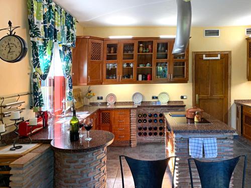 a kitchen with a bar and a counter with chairs at VILLA NABRISA MARBELLA, 5 BEDROOM, PRIVATE POOL, GARDEN, BBQ in Marbella