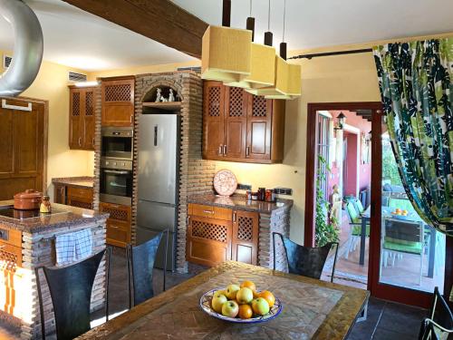 a kitchen with a table with a bowl of fruit on it at VILLA NABRISA MARBELLA, 5 BEDROOM, PRIVATE POOL, GARDEN, BBQ in Marbella