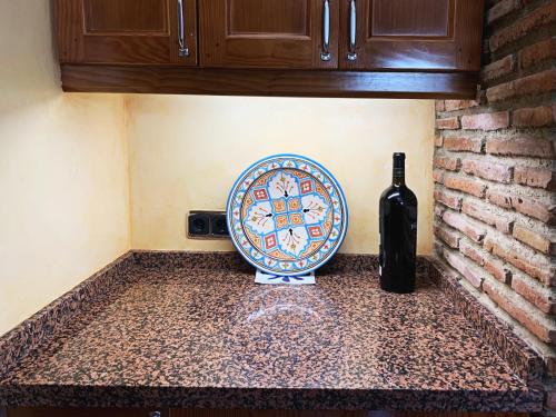 a counter with a plate and a bottle of wine at VILLA NABRISA MARBELLA, 5 BEDROOM, PRIVATE POOL, GARDEN, BBQ in Marbella