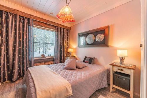 Schlafzimmer mit einem Bett und einem Fenster in der Unterkunft Taruilevi 2 - Villa Levin Taiga - Cabin Close to The Center of Levi in Kittilä