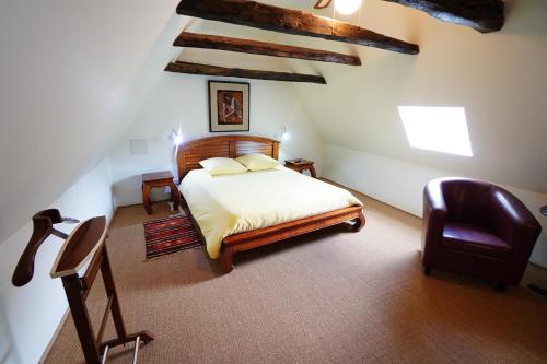une chambre avec un lit et une chaise dans l'établissement LE POTAGER, à Monclard