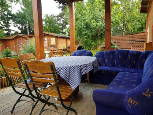 a patio with a table and chairs and a couch at Hacjenda in Radwanice