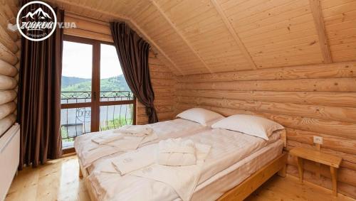 1 dormitorio con 1 cama en una cabaña de madera en Zgarda, en Vorokhta