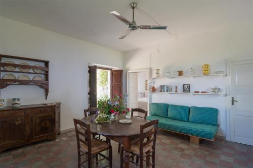 a living room with a table and a blue couch at Case di Berto in Capo Vaticano