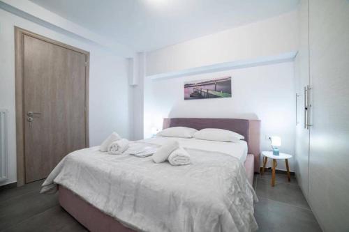 - une chambre avec un lit blanc et des serviettes dans l'établissement Brand New Aprt with backyard in Lycabettus Hill !, à Athènes