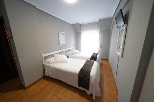 Un dormitorio con una cama blanca y una ventana. en Hotel Isabel, en Isla